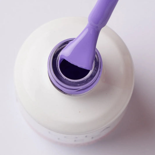 Close-up of lavender gel nail polish bottle with brush coated in purple polish